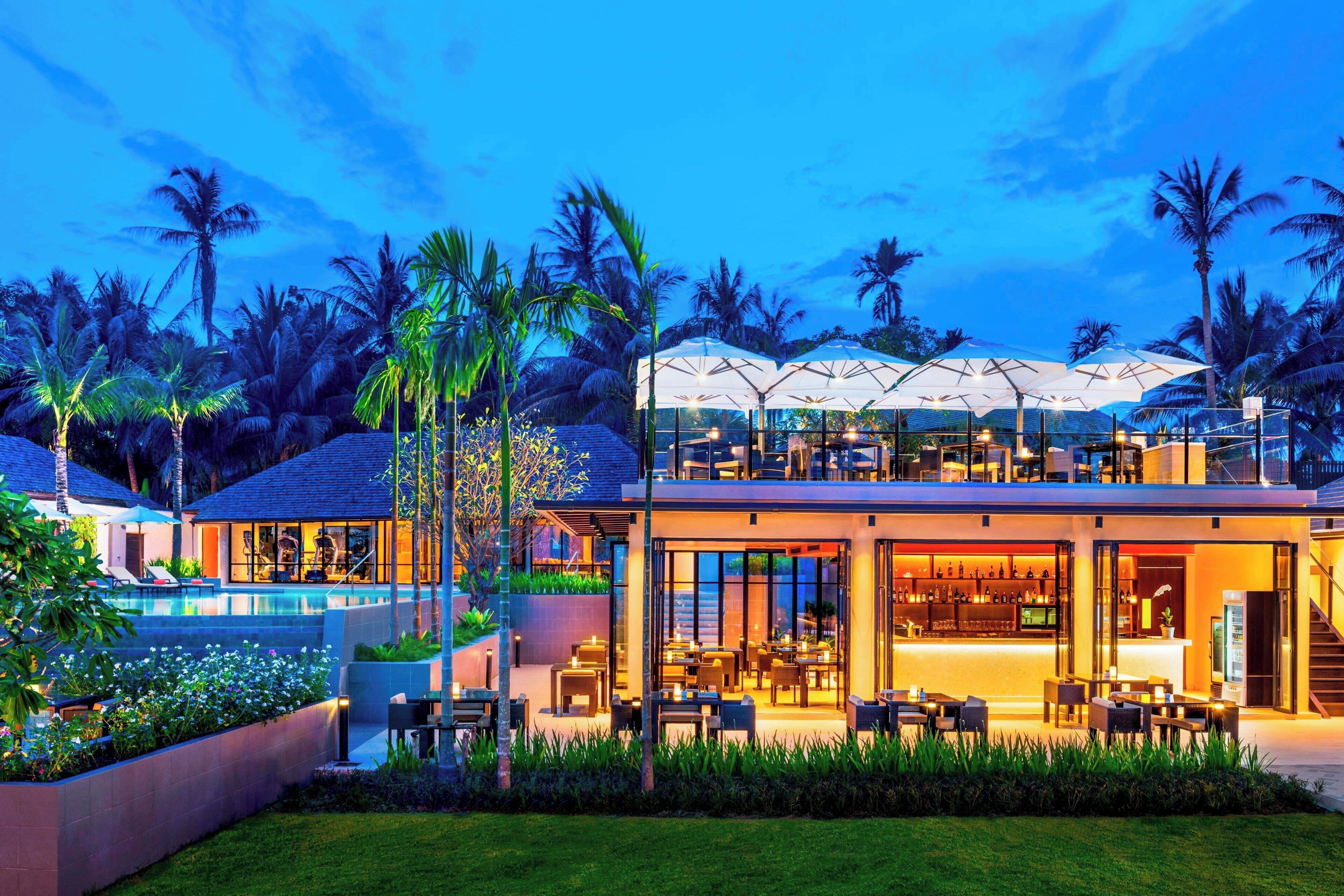 Un resort moderno con piscina, zona de estar al aire libre y bar.