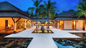 Un resort con edificios de dos pisos, una fuente central y palmeras.