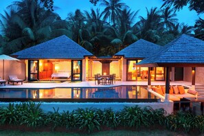 Un complexe hôtelier comprenant deux villas, chacune dotée d’un balcon, d’une piscine et offrant une vue sur les palmiers.