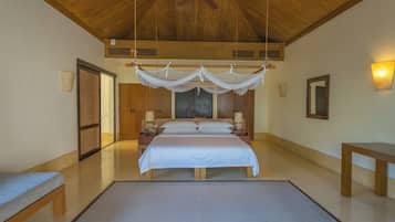 A spacious bedroom with a large bed, a ceiling fan, and a wooden ceiling.