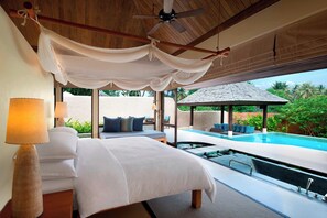 Un dormitorio con una cama grande, un ventilador de techo y vistas a una piscina infinita.