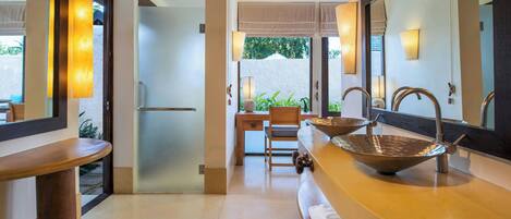 Un baño moderno con un espejo grande, dos lavamanos y un mueble de tocador de madera.