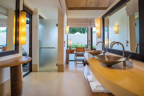 Un baño moderno con un espejo grande, dos lavamanos y un mueble de tocador de madera.