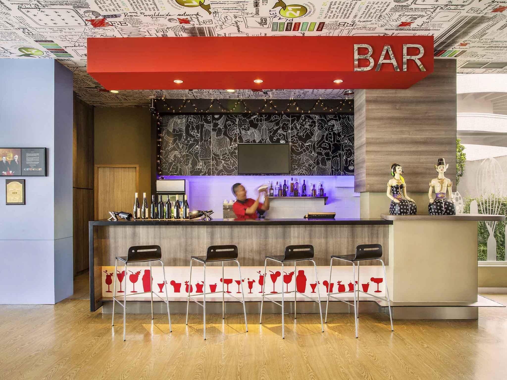 A bar area with a counter, bar stools, and decorative statues.