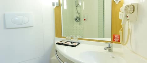Ein Badezimmer mit Toilette, Waschbecken und Spiegel sowie einem Handtuchhalter.