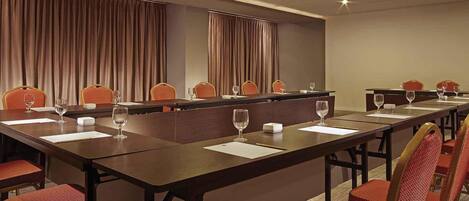 A conference room with a long table, chairs, and glassware.