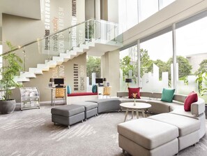 A modern interior with a staircase, seating area, and large windows.