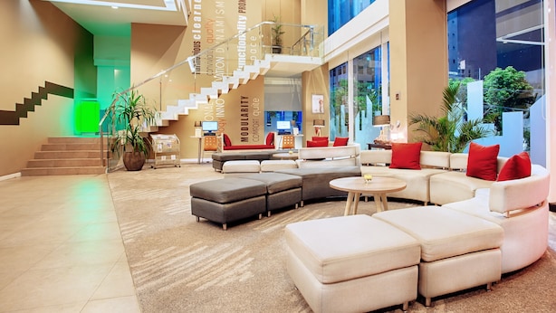 A spacious lobby with a modern staircase, comfortable seating areas, and large windows offering views of the outdoors. - ibis Surabaya City Center (Surabaya)
