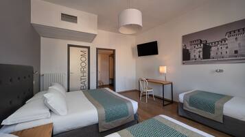 Une chambre d’hôtel avec deux lits, un bureau, une chaise, une télévision et une porte de salle de bain.