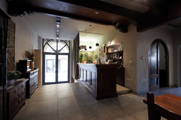 Una cocina amplia con una isla central, un comedor con mesa de madera y un gran arco que da a un espacio exterior.