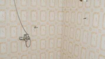 A bathroom with a shower, a toilet, and a sink.