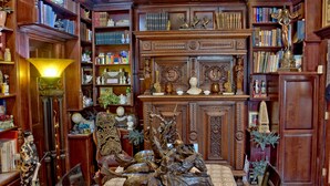A library with wooden bookshelves, a large statue of horses, and various decorative items. - Big Yellow Inn (Cedar City)