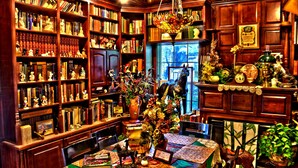 A library with bookshelves, a dining table, and a chandelier. - Big Yellow Inn (Cedar City)