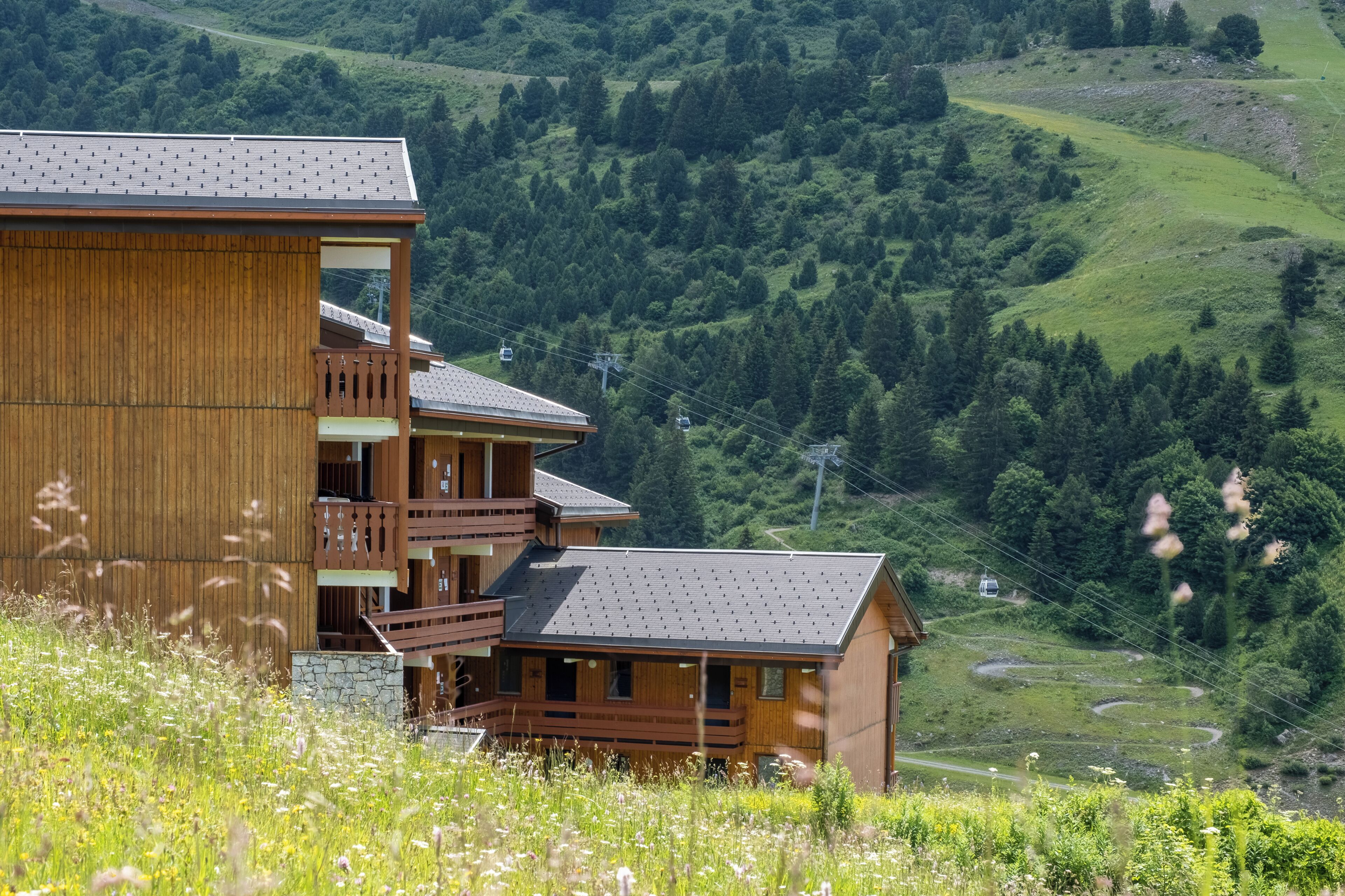 Un chalet en bois doté d’un balcon, situé dans un cadre montagneux.