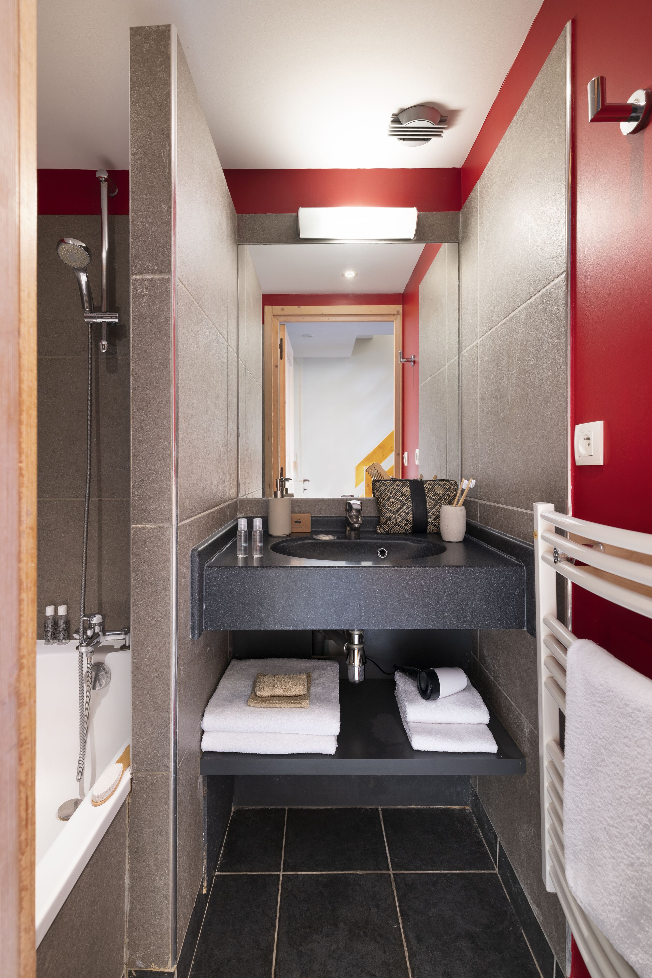 Un baño moderno con ducha, lavamanos y toallero.