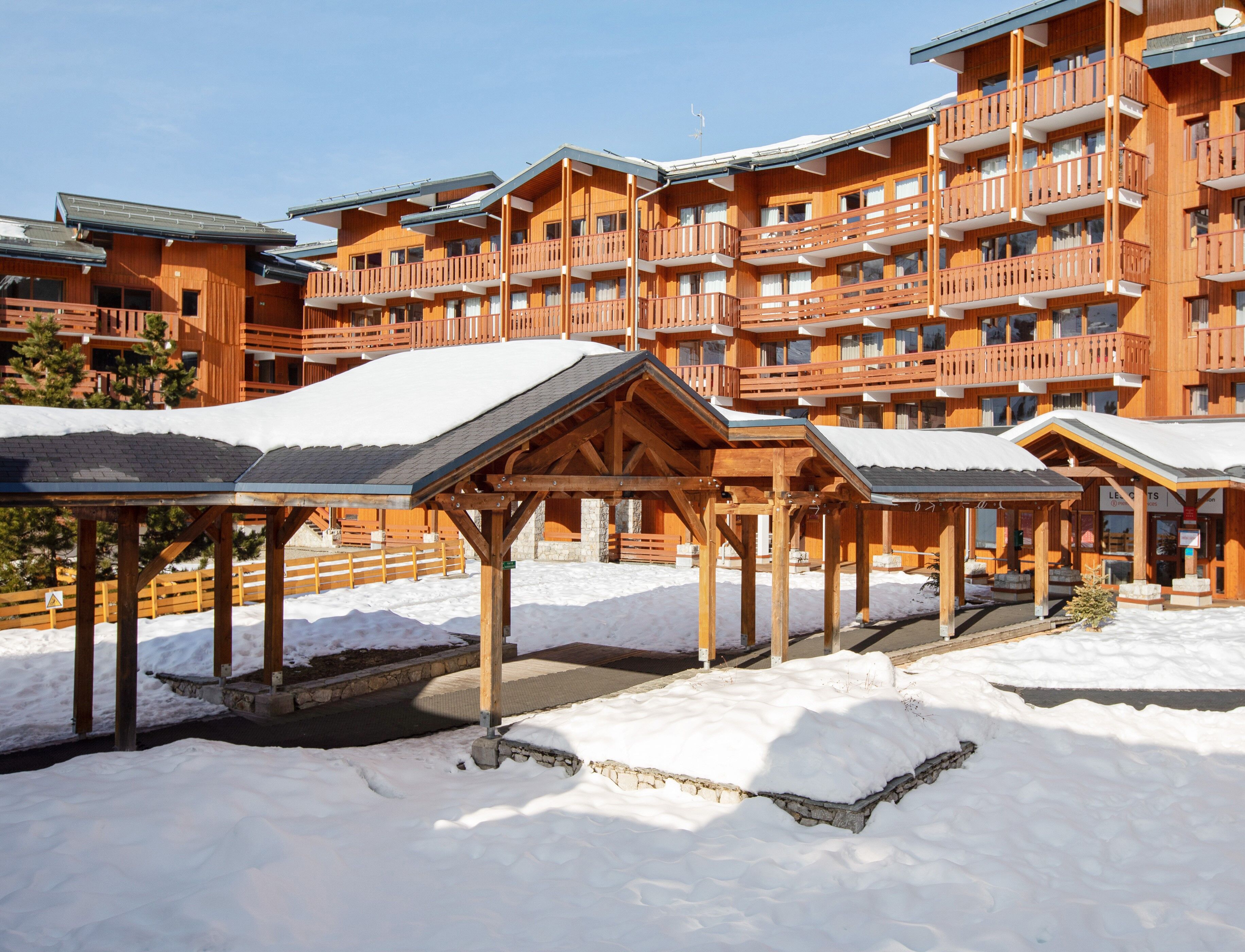 A wooden lodge with multiple balconies and a covered outdoor area.