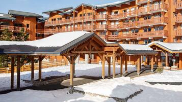 A wooden lodge with multiple balconies and a covered outdoor area.