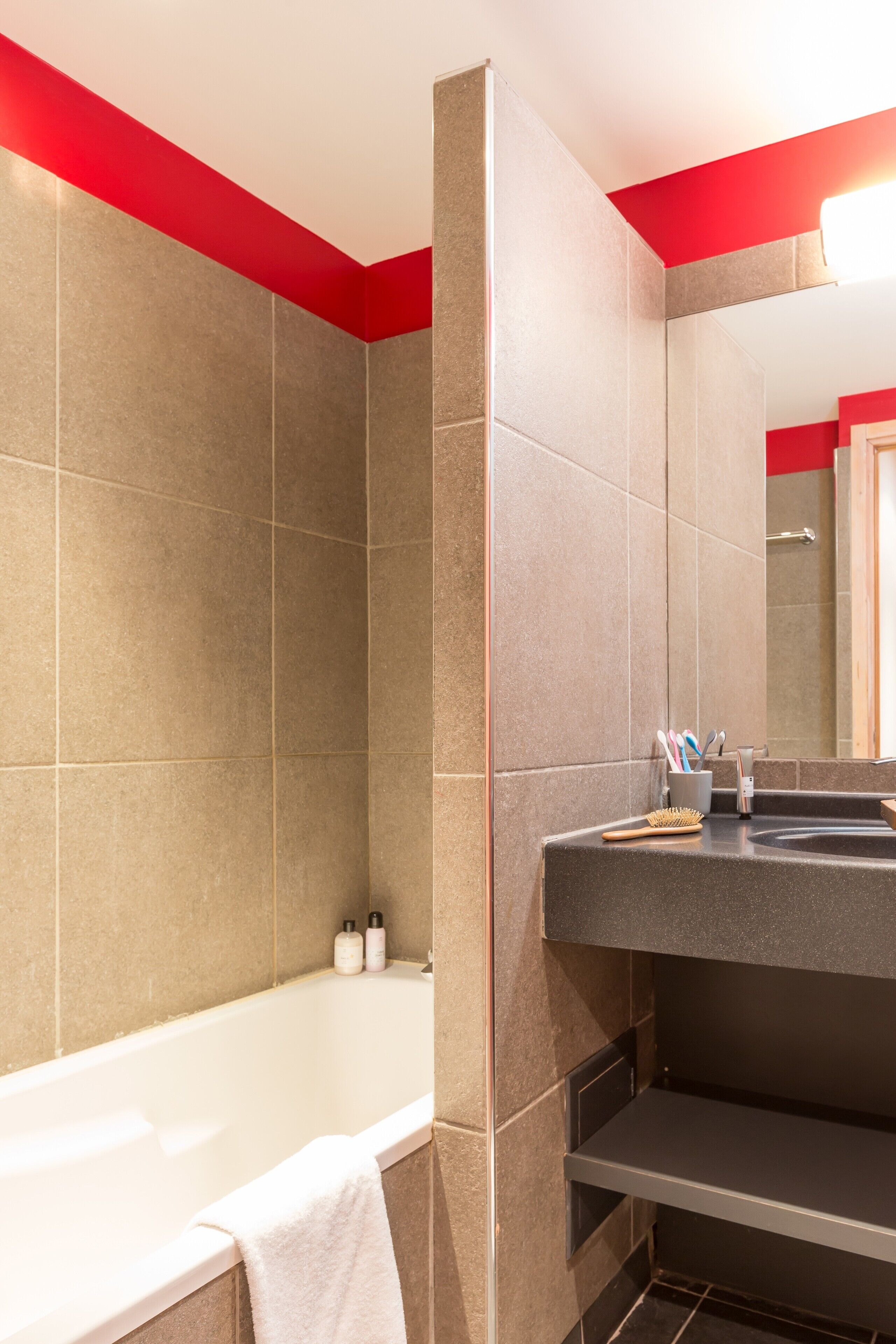 Une salle de bain moderne avec une baignoire, un lavabo et un miroir.