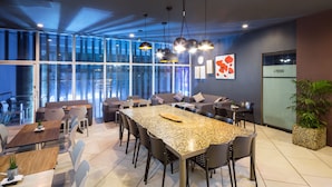 Un comedor moderno con una gran mesa de granito, asientos cómodos y ventanas amplias con vistas a la ciudad.