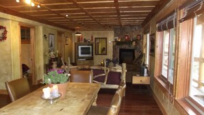 Un comedor acogedor con muebles de madera, chimenea y televisor al fondo.