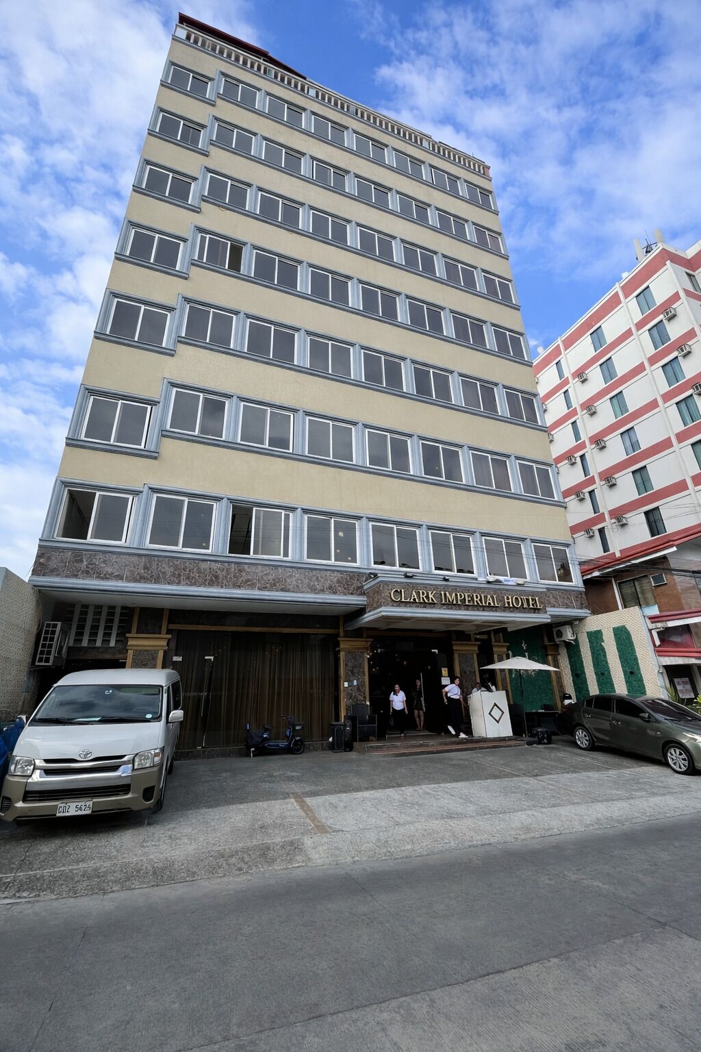 A multi-story hotel with a beige facade, named 'Clark Imperial Hotel'.