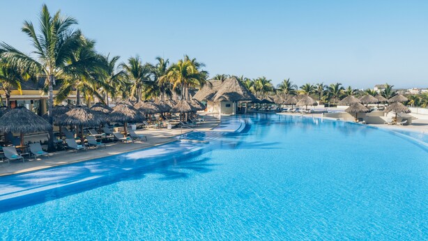A large, clear swimming pool with lounge chairs and palm trees. - Iberostar Selection Playa Mita - All Inclusive (Punta de Mita)