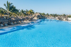 A large, clear swimming pool with lounge chairs and palm trees. - Iberostar Selection Playa Mita - All Inclusive (Punta de Mita)