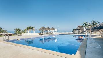 Relax by the serene pool, surrounded by ocean views and shaded seating areas.