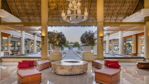 A spacious lobby with a central seating area, a thatched roof, and a view of the outdoor area. - Iberostar Selection Playa Mita - All Inclusive (Punta de Mita)