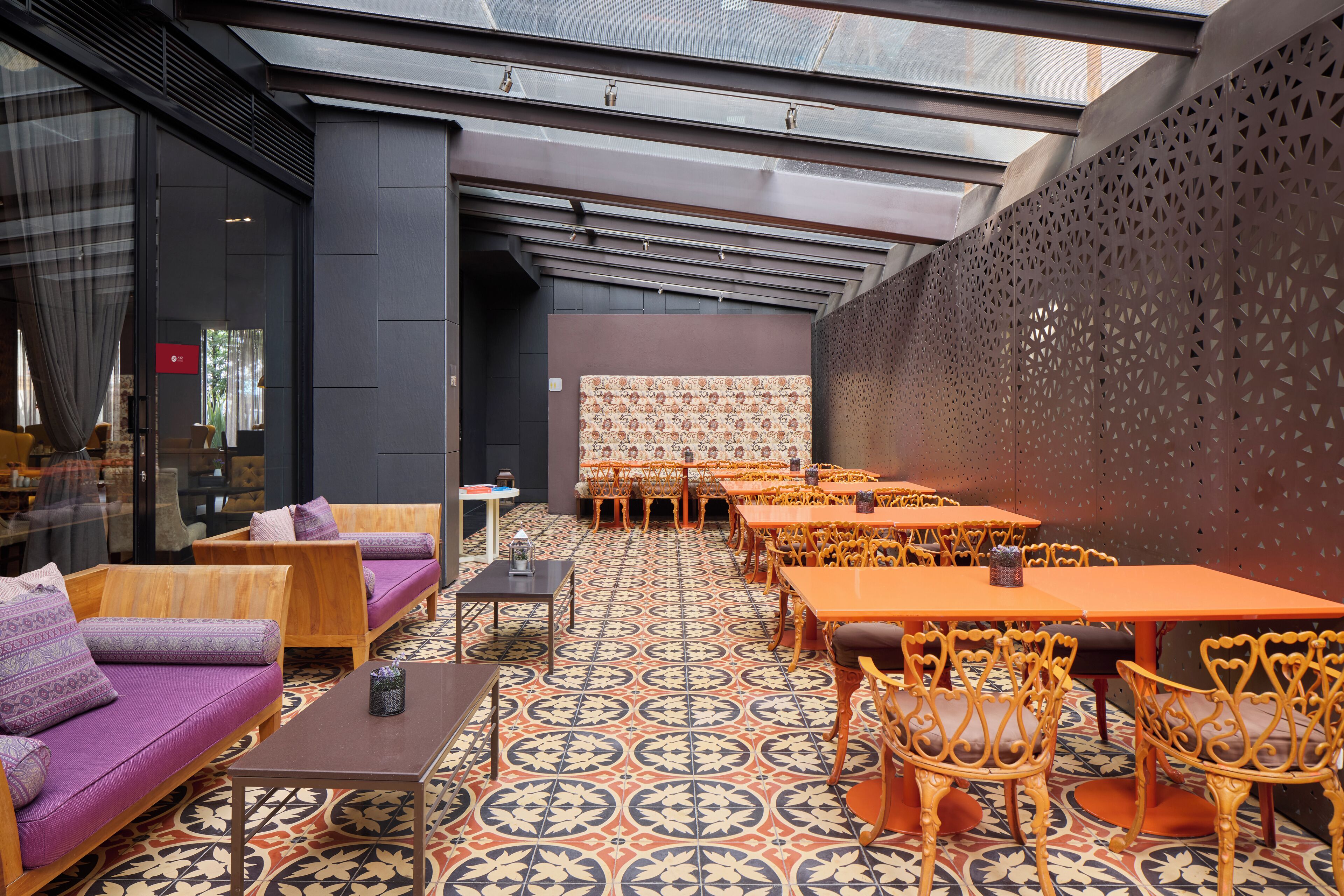 A modern interior with seating areas, tables, and patterned flooring.
