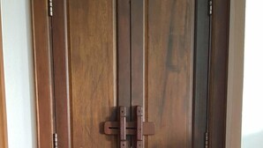 A double wooden door with a central lock and two side handles. - Ping Phu Place (Chiang Mai)