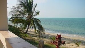 A beach view with palm trees, a small structure, and a clear sky. - New Sunrise Village Bang Po Beach (Koh Samui)