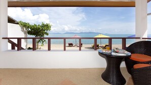 A balcony with a view of the beach, a table with chairs, and beach chairs. - The Cosy Beach Resort (Koh Samui)