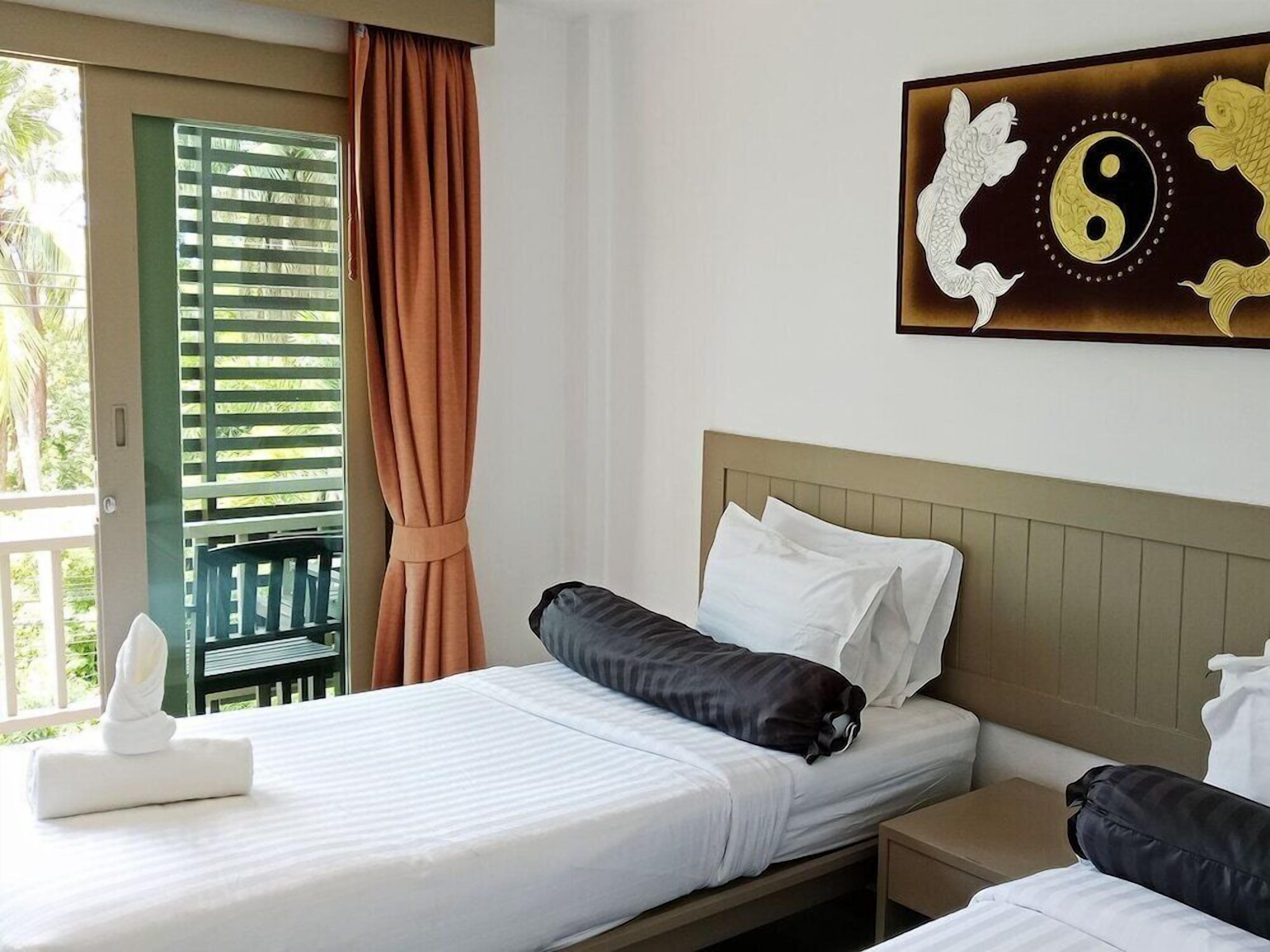 A hotel room with a bed, a nightstand, and a wall-mounted artwork.