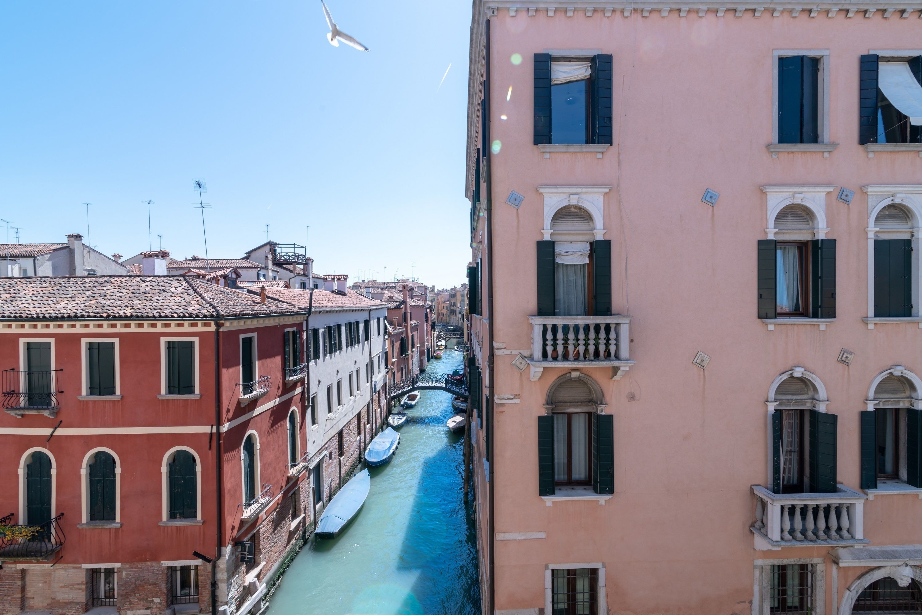 Un canal con barcos, rodeado de edificios con balcones y ventanas arqueadas.
