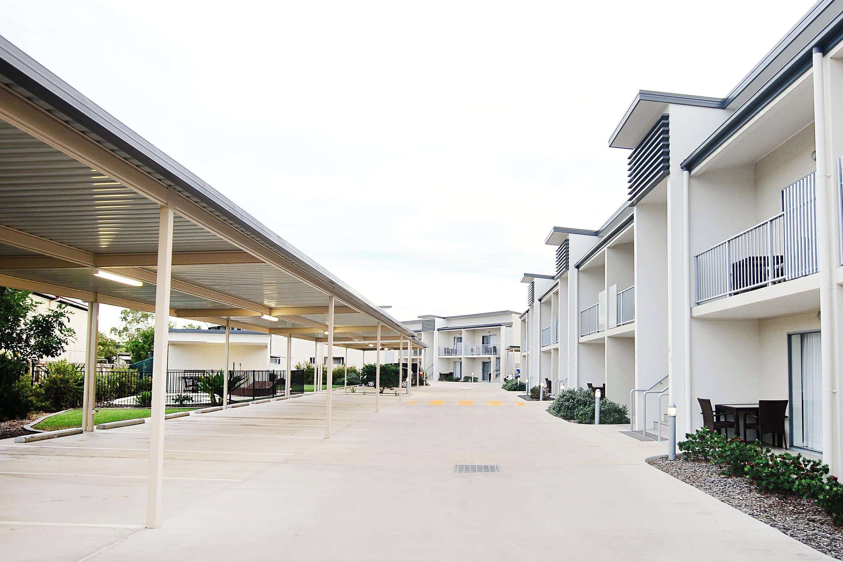 A modern building with covered walkways and outdoor seating areas.