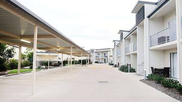 A modern building with covered walkways and outdoor seating areas.