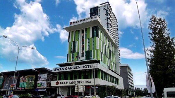 Ein mehrstöckiges Gebäude mit einem Schild für das SWAN GARDEN HOTEL und die BANK OF CHINA.