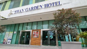 Das Swan Garden Hotel mit moderner Fassade, großen Glasfenstern und einem markanten Eingang.