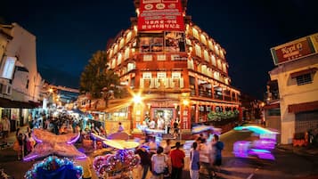 A multi-story building with illuminated signage and a crowd of people in front.