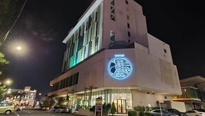 Un edificio con un llamativo letrero iluminado que dice 'The Kam Ching Restaurant' de noche.