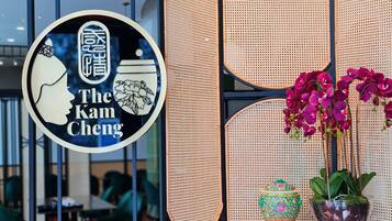 A restaurant sign with a woman's profile and the name "The Kam Cheng".