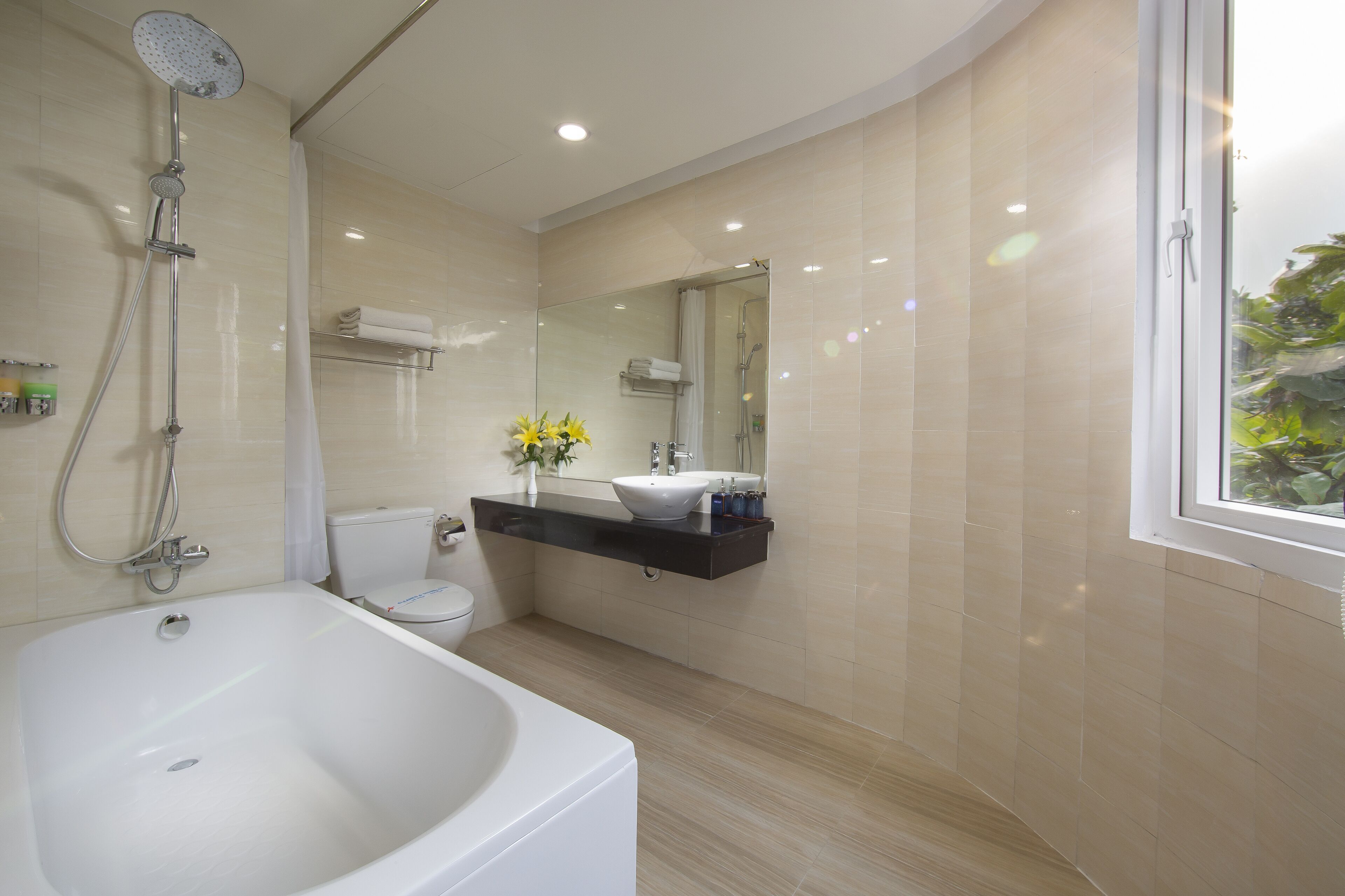 Ein modernes Badezimmer mit Badewanne, Toilette und Dusche.