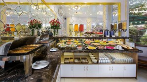 A buffet with a variety of food options, including fruits, vegetables, and prepared dishes.