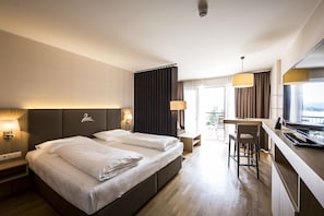Hotellihuone, jossa on suuri sänky, työpöytä ja näkymä ulos.