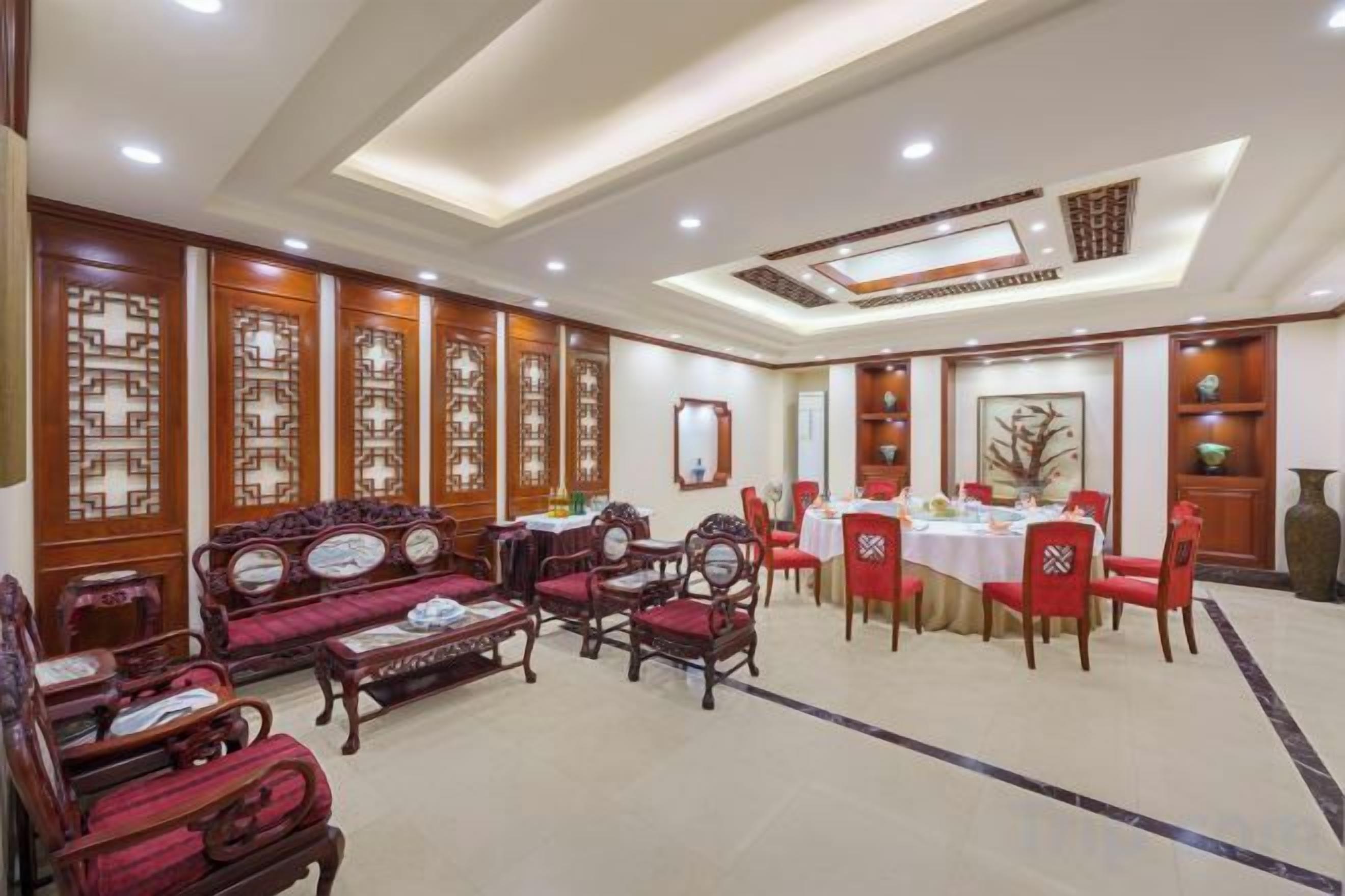 A hotel lobby with traditional decor, including wooden furniture and a dining area.