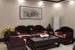 A room with a sofa set, a coffee table, and a framed artwork on the wall. - Sihai Grand Hotel (Anshan)