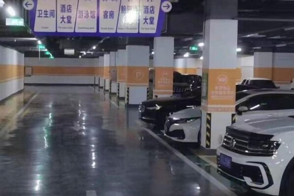 A parking garage with multiple levels, marked parking spaces, and directional signs. - Sihai Grand Hotel (Anshan)
