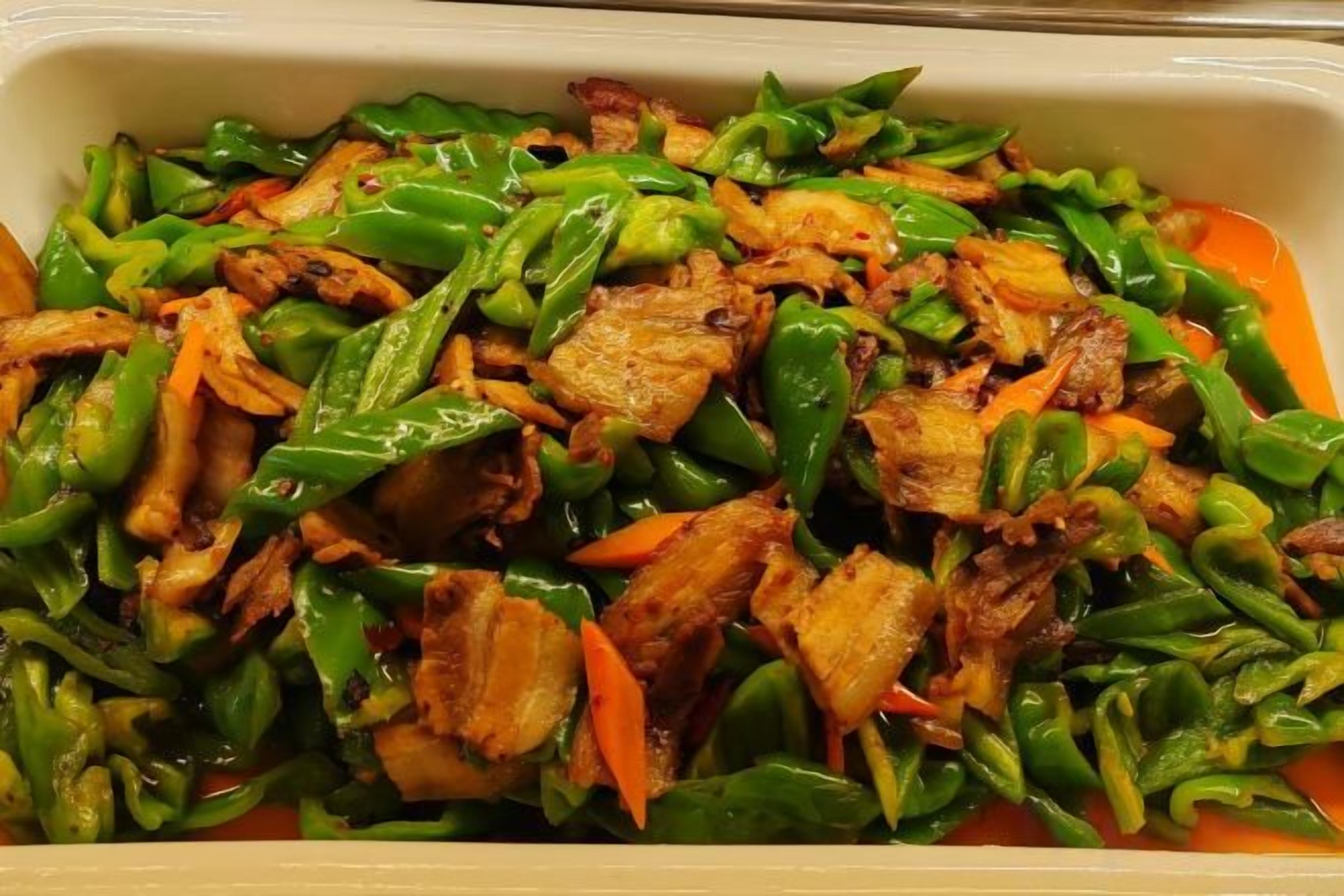 A rectangular dish containing stir-fried vegetables and meat.