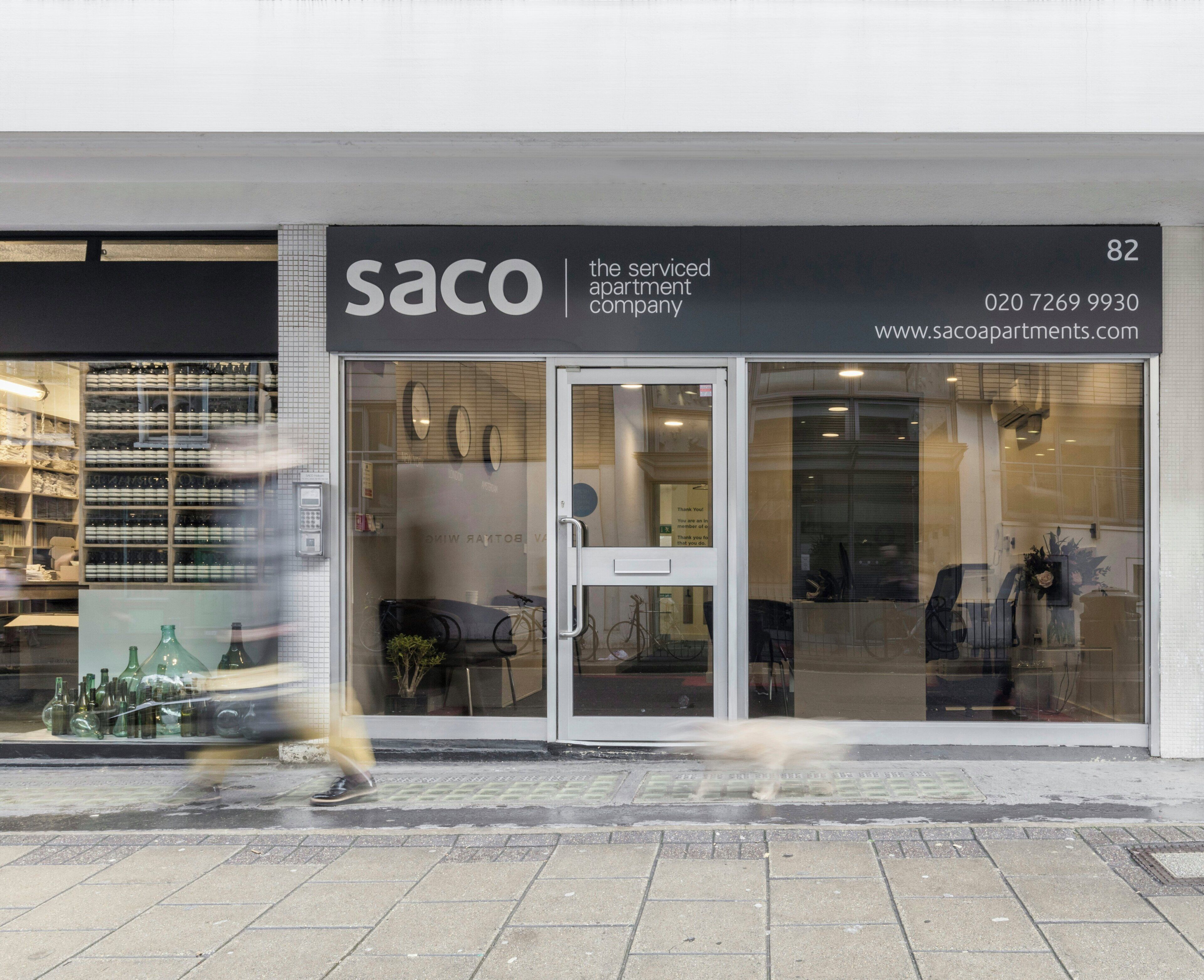 A storefront with the name 'SACO' and a contact number.